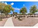 Serene community park with winding walkway, lush landscaping, and covered picnic area at 19887 N Herbert Ave, Maricopa, AZ 85138