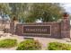 Stone entrance sign for Homestead, surrounded by lush landscaping, welcomes residents and visitors at 19887 N Herbert Ave, Maricopa, AZ 85138