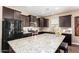 This kitchen features stainless steel appliances, granite counters, and dark wood cabinets at 19887 N Herbert Ave, Maricopa, AZ 85138