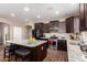 Modern kitchen with dark cabinets, granite countertops, stainless steel appliances, and an island with seating at 19887 N Herbert Ave, Maricopa, AZ 85138