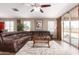 Comfortable living room with a large sectional sofa, ceiling fan, and access to the backyard at 19887 N Herbert Ave, Maricopa, AZ 85138