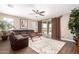 Spacious living room with a large sectional sofa, ceiling fan, and sliding glass doors to the patio at 19887 N Herbert Ave, Maricopa, AZ 85138