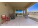 Covered patio with ample seating, sliding glass doors, and neutral wall paint at 19887 N Herbert Ave, Maricopa, AZ 85138