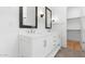 Bright bathroom featuring a double sink vanity with modern fixtures and a walk-in closet at 20302 W Turney Ave, Buckeye, AZ 85396