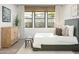Bright bedroom with a large window and a wooden accent table and cabinet at 20309 W Roma Ave, Buckeye, AZ 85396