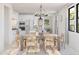 Open-concept dining area with a wooden table, chairs, and a view into the modern kitchen at 20309 W Roma Ave, Buckeye, AZ 85396
