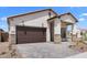 Charming single-Gathering home showcasing a two-car garage, stone accents, and a well-maintained front yard at 20302 W Turney Ave, Buckeye, AZ 85396