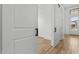 Hallway with wood-look floors, neutral paint, and white doors with black hardware at 20302 W Turney Ave, Buckeye, AZ 85396