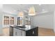 Contemporary kitchen featuring an island with sink and pendant lights, and views of the living area at 20302 W Turney Ave, Buckeye, AZ 85396