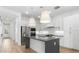 Bright kitchen with white cabinets, stainless steel appliances, and a center island with a gray countertop at 20302 W Turney Ave, Buckeye, AZ 85396