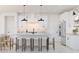 Modern white kitchen with a center island, stainless steel appliances, and stylish pendant lighting at 20309 W Roma Ave, Buckeye, AZ 85396