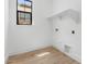 Well-lit laundry room with wood-look flooring, a window, and convenient shelving at 20302 W Turney Ave, Buckeye, AZ 85396