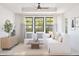 Cozy living room with white seating, natural light, and a view of the beautifully landscaped exterior at 20309 W Roma Ave, Buckeye, AZ 85396