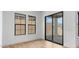 An open living space featuring black-framed windows, wood floors and a sliding door to the backyard at 20302 W Turney Ave, Buckeye, AZ 85396
