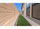A narrow side yard featuring pavers, turf, a tall block wall, and well-placed landscaping at 20302 W Turney Ave, Buckeye, AZ 85396