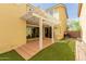Charming backyard featuring a covered patio with string lights, lush turf, and neutral-toned two-story house at 20733 W Alsap Rd, Buckeye, AZ 85396