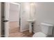 Bright powder room boasts a pedestal sink and toilet with modern fixtures and a tile floor at 20733 W Alsap Rd, Buckeye, AZ 85396