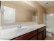 Bathroom featuring wood cabinets, white countertop, large mirror, and a shower-tub combo at 20733 W Alsap Rd, Buckeye, AZ 85396