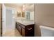 Bathroom with tile floor, wood cabinets, white countertop, mirror, and a doorway to the next room at 20733 W Alsap Rd, Buckeye, AZ 85396