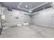 Spacious garage with a modern design including gray walls, an overhead storage rack, and epoxy-sealed concrete floors at 20733 W Alsap Rd, Buckeye, AZ 85396