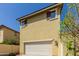 Exterior shot of two-car garage, neutral-toned stucco, and a well-manicured yard. Ideal curb appeal at 20733 W Alsap Rd, Buckeye, AZ 85396