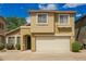 Tan home with a white garage door, landscaped yard, and blue sky at 21840 N 41St St, Phoenix, AZ 85050