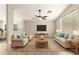 Bright living room features neutral tones, ceiling fan, and large windows for natural light at 21840 N 41St St, Phoenix, AZ 85050