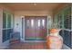 Welcoming front porch with decorative potted plant, seating and custom designed double front doors at 25639 S Beech Creek Dr, Sun Lakes, AZ 85248
