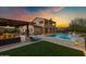 Expansive backyard boasts a pool, spa, lounge area, and outdoor kitchen under a pergola at 30129 N 52Nd Pl, Cave Creek, AZ 85331