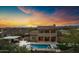 Stunning backyard oasis at dusk with a large pool, spa, outdoor kitchen, and manicured landscaping at 30129 N 52Nd Pl, Cave Creek, AZ 85331