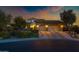 Exterior evening shot of home with stone accents, a three-car garage and manicured front lawn at 30129 N 52Nd Pl, Cave Creek, AZ 85331