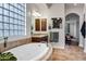 Bright bathroom with soaking tub, vanity, and glass block window providing natural light and privacy at 30129 N 52Nd Pl, Cave Creek, AZ 85331