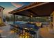 An outdoor kitchen and covered seating area overlooks the pool, spa, and backyard landscape at 30129 N 52Nd Pl, Cave Creek, AZ 85331