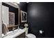 Stylish powder room boasts dark walls, decorative gold mirror, and elegant fixtures at 30129 N 52Nd Pl, Cave Creek, AZ 85331
