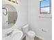 This bathroom features a large sink with a round mirror, a toilet, and a window at 3013 S 102Nd Ln, Tolleson, AZ 85353