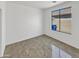 Bright, minimalist bedroom featuring tiled floor and a large window, offering space and natural light at 3013 S 102Nd Ln, Tolleson, AZ 85353