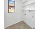 A laundry room features a large window, upper cabinets, and washer and dryer hookups at 3013 S 102Nd Ln, Tolleson, AZ 85353