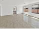 An open-concept living room is bathed in natural light from large windows and features tile floors at 3013 S 102Nd Ln, Tolleson, AZ 85353
