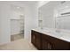 Bright bathroom with double vanity, tiled floor, walk-in shower, and access to walk-in closet at 37126 W Prado St, Maricopa, AZ 85138