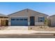 Charming single-story home featuring a blue garage door and desert landscaping at 37126 W Prado St, Maricopa, AZ 85138