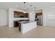 Spacious open kitchen with an island, stainless steel appliances, and ample countertop space at 37126 W Prado St, Maricopa, AZ 85138