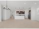 Expansive living room with tile, transitioning to a kitchen with dark cabinets at 37126 W Prado St, Maricopa, AZ 85138