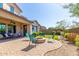 Beautiful backyard with a cozy fire pit area, patio seating, lush landscaping, and well-manicured lawn at 3751 E Zachary Dr, Phoenix, AZ 85050