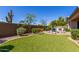 A relaxing backyard featuring an outdoor kitchen, well-manicured lawn and desert landscaping at 3751 E Zachary Dr, Phoenix, AZ 85050
