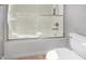 Bright bathroom features a bathtub with a sliding glass door and a white toilet at 3751 E Zachary Dr, Phoenix, AZ 85050