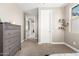 Cozy bedroom featuring neutral carpet, a window, a dresser with shelves and a glimpse into the ensuite bathroom at 3751 E Zachary Dr, Phoenix, AZ 85050