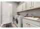 Functional laundry room with white cabinets, sink, and modern washer and dryer units at 3751 E Zachary Dr, Phoenix, AZ 85050