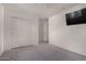 This bedroom features carpeted floors, a ceiling fan, a TV and closet for storage at 42311 W Bunker Dr, Maricopa, AZ 85138