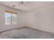 Bright, airy bedroom featuring a large window and ceiling fan at 42311 W Bunker Dr, Maricopa, AZ 85138