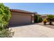 Picture of a home's two-car garage and landscaped front yard, including desert foliage at 42311 W Bunker Dr, Maricopa, AZ 85138